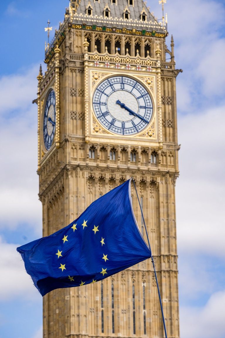 UK–EU Cooperation in 2026: What the TCA Review and New Agreements Mean for Business Flags of the United Kingdom and the European Union framing official government headquarters in London and Brussels. UK-EU cooperation 2026